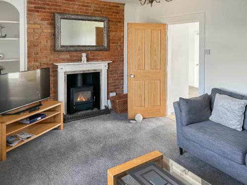 a living room with a couch and a fireplace at Church View in Hunstanton