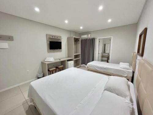a hospital room with two beds and a tv at Pousada Bela By Bia - Comfort in Penha