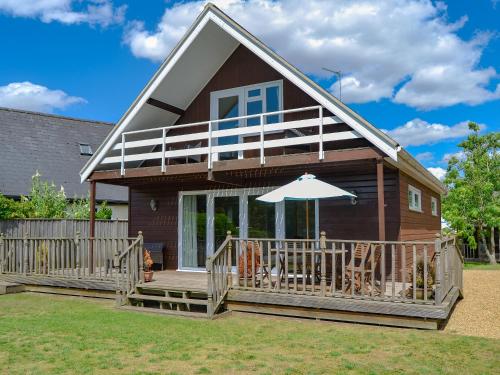 a house with a deck and an umbrella at Watersedge - E1106 in Horning