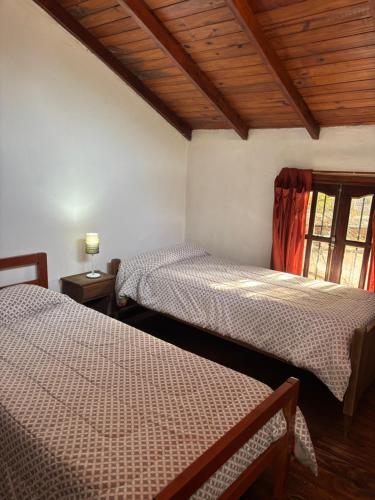 ein Schlafzimmer mit zwei Betten und einem Fenster in der Unterkunft Aneley Cabañas Bosque Peralta Ramos in Mar del Plata