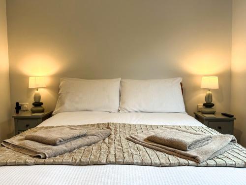 a bedroom with a bed with two lamps on both sides at Lower Moon in Port Isaac