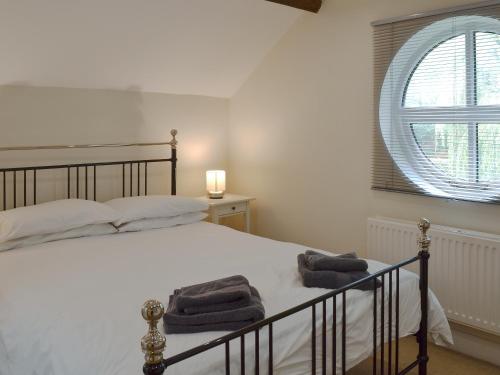 a bedroom with a bed with towels on it at The Old Stables in Standon