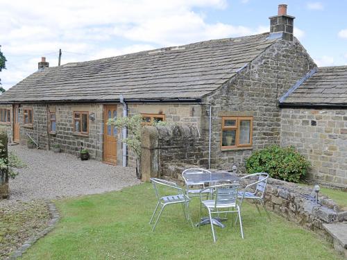 a table and chairs in front of a stone house at Crossgates - 9562 in Grantley
