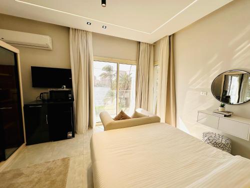 a bedroom with a bed and a mirror and a chair at ROOMES NILE VIEW MANIEl in Cairo