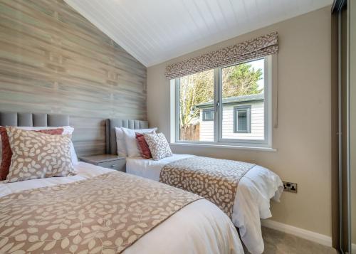 two beds in a bedroom with a window at Faringdon Grange in Faringdon