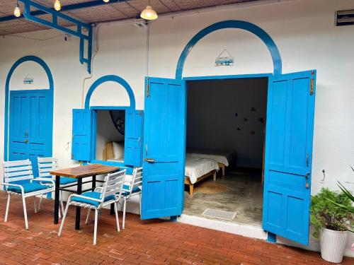 a room with blue doors and a table and chairs at Homestay Văn Vĩnh Hy 3 in Ninh Hải