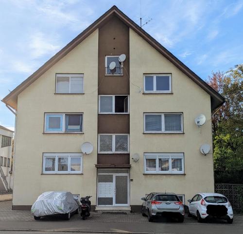 a house with two cars parked in front of it at Gemütliches, renoviertes Appartement in Uniklinik- & City- Nähe mit Klimaanlage in Homburg