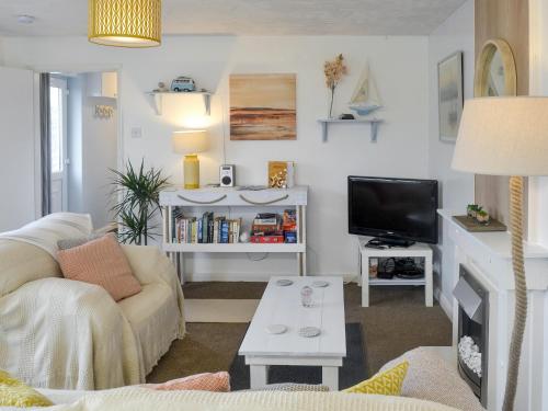 a living room with a couch and a tv at The Loft in Amlwch