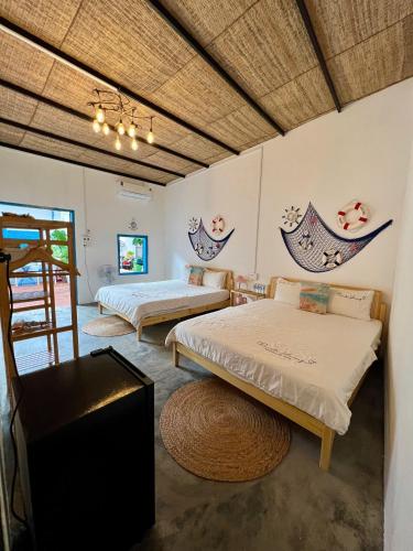 a room with two beds and a table at Homestay Văn Vĩnh Hy 3 in Ninh Hải