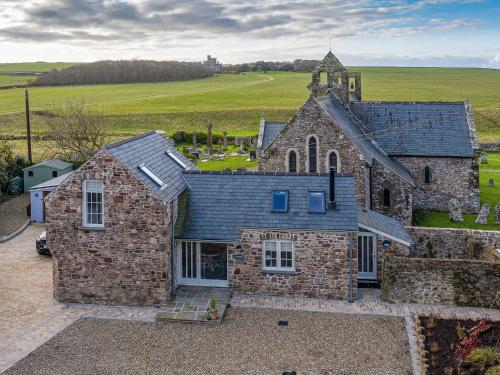 an aerial view of a stone building with a church at Cranford-Cottage in Saint Brides