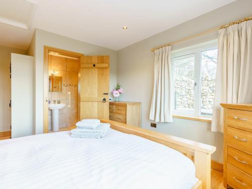 a bedroom with a large white bed and a sink at Limecroft in Malham