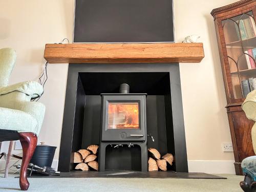 a living room with a fireplace with a tv at Point Park in Taynuilt