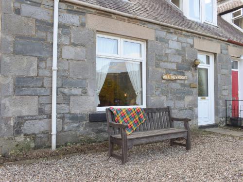 a bench with a blanket sitting in front of a building at Hill View House in Aberfeldy