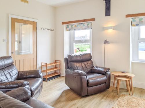 a living room with a couch and a chair at Seascape Cottage in Allonby