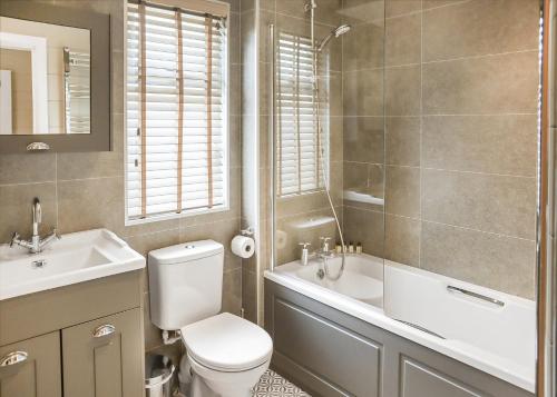 a bathroom with a toilet and a tub and a sink at Thirlestane Woodland Lodges in Lauder
