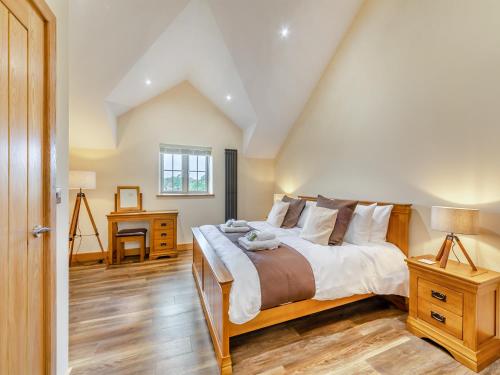 a bedroom with a large bed and a wooden floor at Garth House - Castlesteads in Brampton