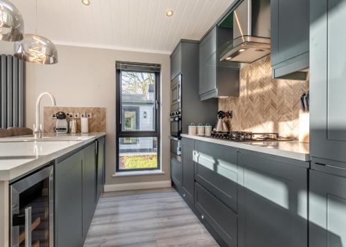 a kitchen with blue cabinets and a window at Faringdon Grange in Faringdon