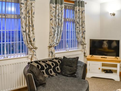 a living room with a couch and a tv at Stonebank Cottage - Uk35686 in Hunwick