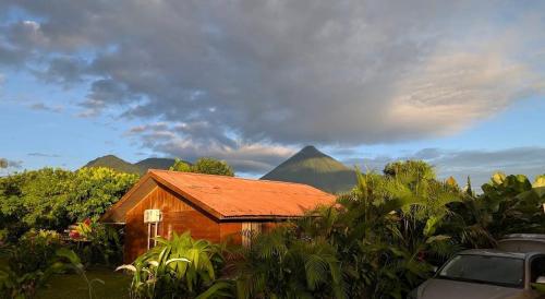 a small wooden house with mountains in the background at Cabaña Rural el Mirador in Fortuna