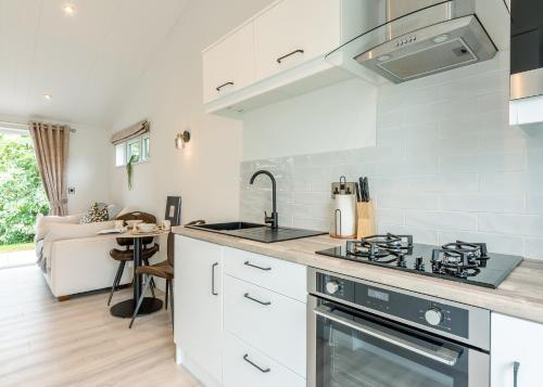 a kitchen with white cabinets and a stove top oven at Faringdon Grange in Faringdon