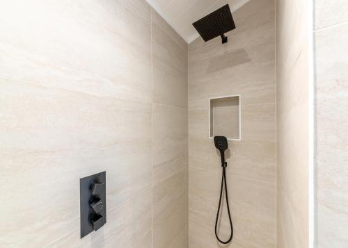 a shower in a bathroom with a phone on the wall at Faringdon Grange in Faringdon