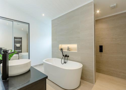a bathroom with a white tub and a sink at Faringdon Grange in Faringdon