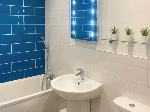 a white bathroom with a sink and a mirror at The Holiday House in Benllech