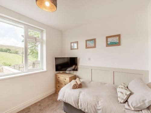 a bedroom with a bed and a tv and a window at Vallum Villa - Uk40231 in Bardon Mill