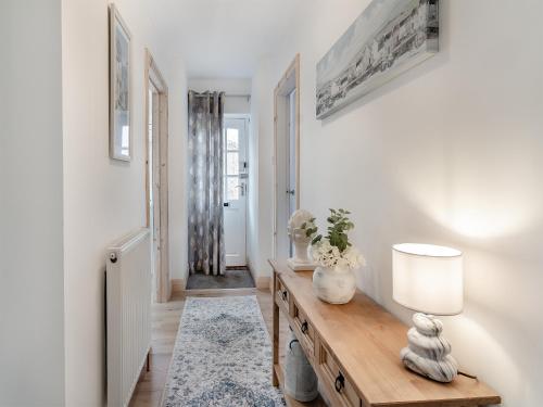 a living room with a table and a lamp at Heritage Cottage in Flamborough