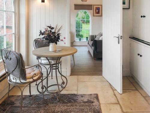 a room with a table and chairs and a living room at The Little Cottage in Fittleworth