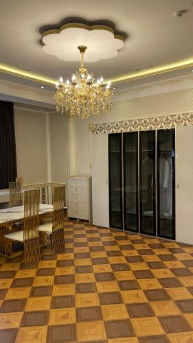 a dining room with a table and chairs and a chandelier at Hotel Madonna SPA in Kaskelen