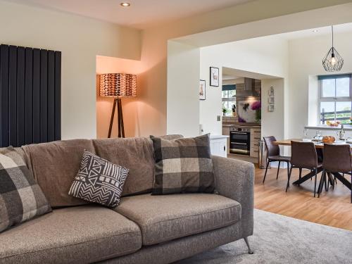 un salon avec un canapé et une salle à manger dans l'établissement Swiss Cottage, à Scotforth