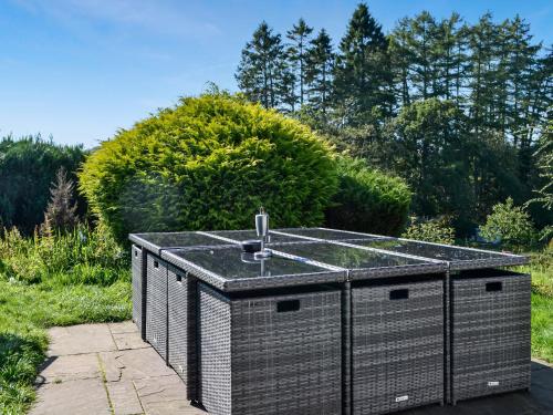 a hot tub in a garden with a fountain at The Granary - Uk45181 in Newcastleton