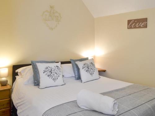 a bedroom with a bed with white sheets and pillows at Belgian Cottage in Sewerby