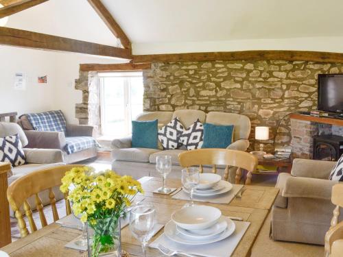 a living room with a table and a stone wall at Woodland View-Uk11826 in Llandefaelogfâch