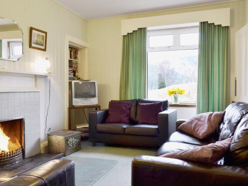 a living room with a couch and a fireplace at Tigh-An-Achaidh in Inverinate