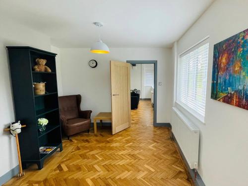 a living room with a chair and a door at Warren Lodge in Little Baddow