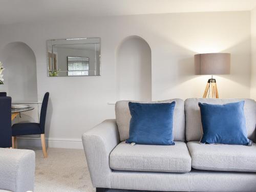 a living room with a couch with blue pillows at Station Cottage in Silverdale
