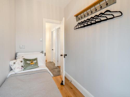 a small bedroom with a bed and a shelf at Number Seven in High Bentham