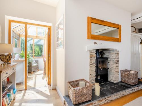 sala de estar con chimenea y espejo en Toffee Apple, en Hemborough Post