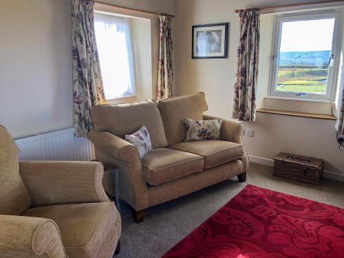 un soggiorno con un divano e una poltrona di Borrowdale Cottage a Brough