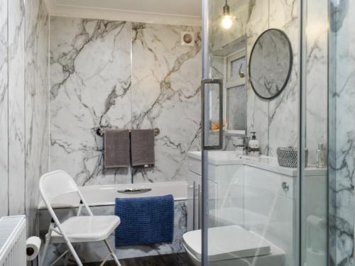 a bathroom with a shower and a toilet and a sink at Coast To Coast Cottage in Cleator Moor