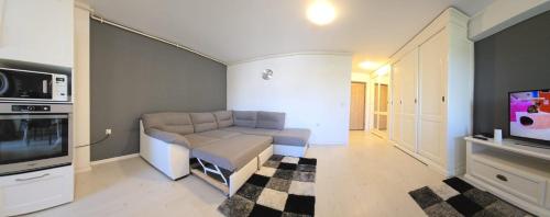 a living room with a couch and a tv at Airport Residence in Otopeni