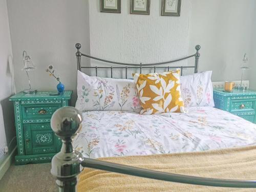 a bedroom with a bed with pillows and two night stands at Hysryb Cottage in Cardiff