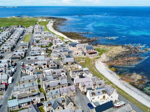 an aerial view of a village next to the ocean at The Hobbit in Inverallochy