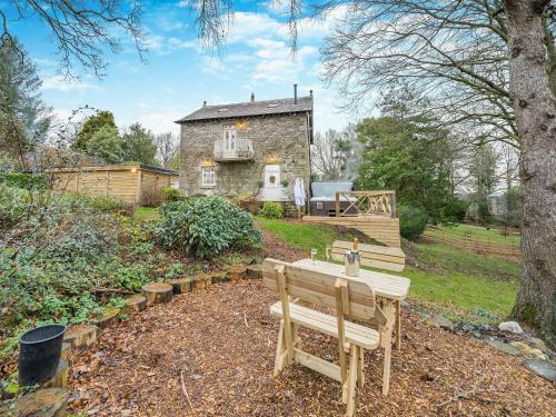 a wooden bench in front of a stone house at The B Hive At Buckstone House in Carnforth