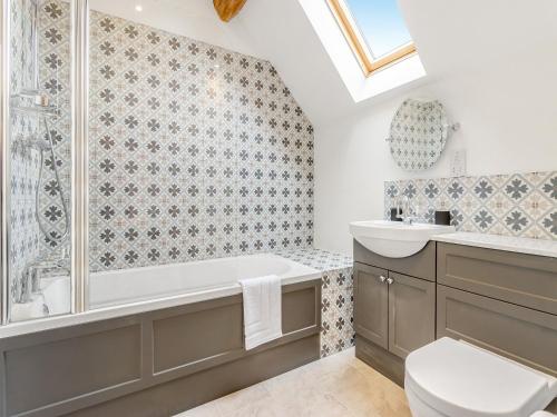 a bathroom with a tub and a toilet and a sink at Orchard Barns - Uk47200 in Stapleton