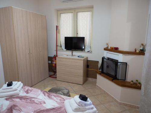 a living room with a bed and a tv at Il Paradiso Verde in Pagani