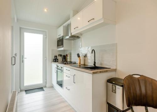 a kitchen with white cabinets and a sink at Faringdon Grange in Faringdon