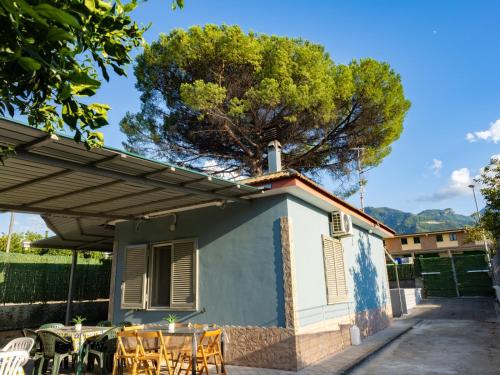 a house with tables and chairs and a tree at Il Paradiso Verde in Pagani